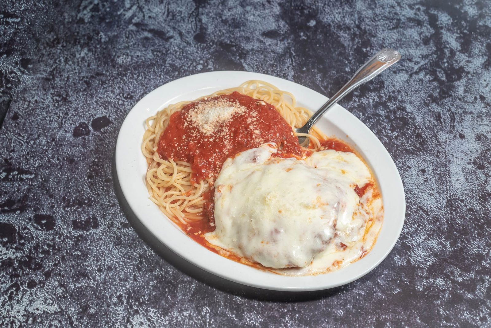 Chicken parmigiana over spaghetti